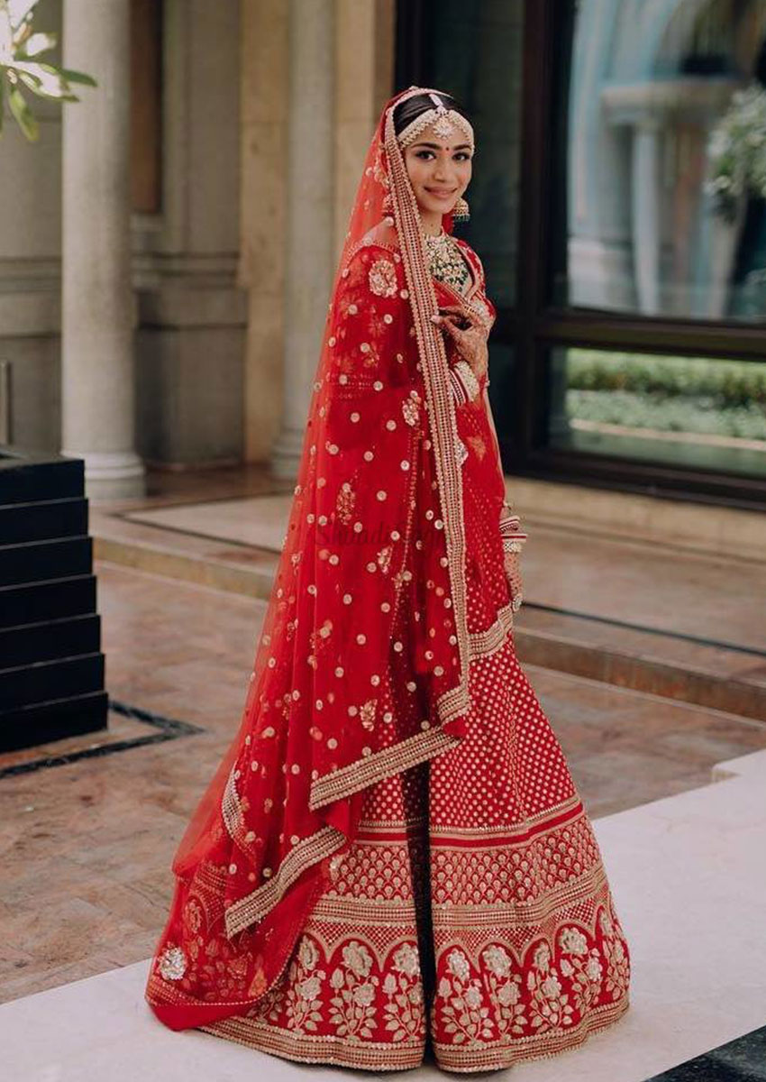 Our beautiful couple make a grand entrance on their big day with our  customized red bridal lehenga and ivory-gold accent groom sherwani! ... |  Instagram