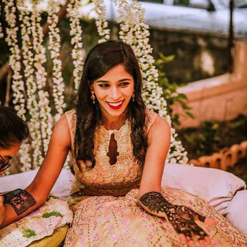 Photo of Bride posing with her mother and sister on her Mehndi ceremony